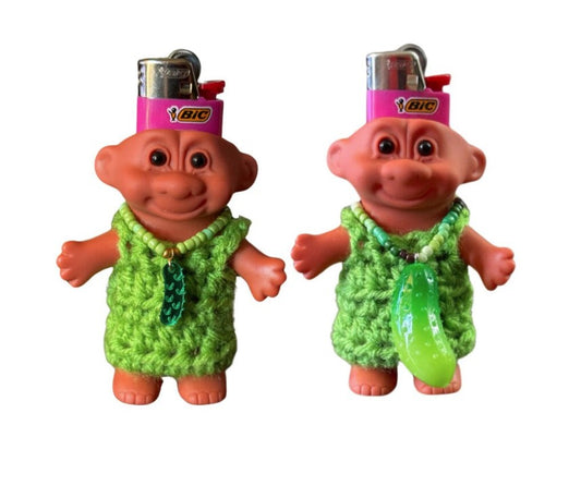 Troll Lighter covers. Both wearing green dress. One has a small pickle necklace and the other is  large pickle necklace